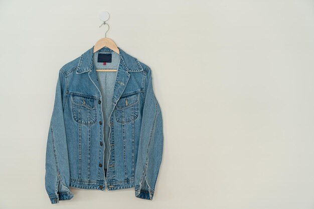 Photo jacket jean hanging with wood hanger on wall