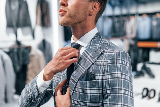 In jacket with tie Young guy in modern store with new clothes Elegant expensive wear for men