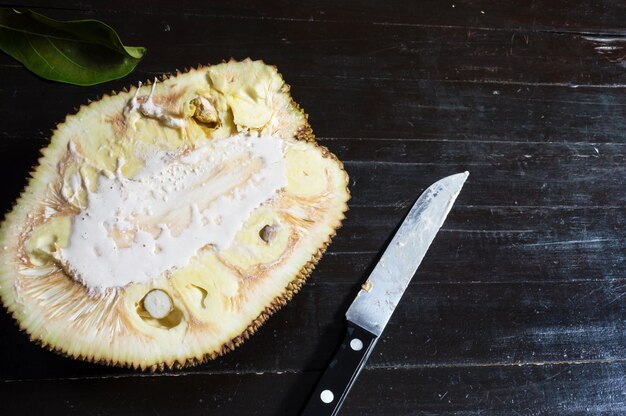 Foto jackfruit tagliato a metà con un coltello sul lato