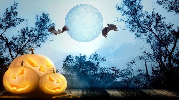 Фото jackolantern на деревянном полу с летучими мышами в туманном лесу на фоне полной луны концепция обоев хэллоуина