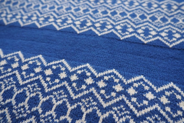 Jacquard gebreid patroon gebreid met witte draad ruiten en zigzag op een blauwe achtergrond geomet