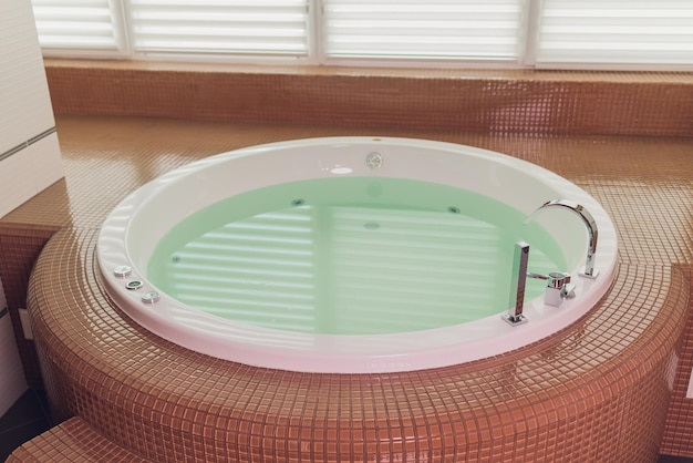 Jacuzzi bath tub on marble floor with water