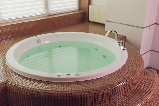 Jacuzzi bath tub on marble floor with water