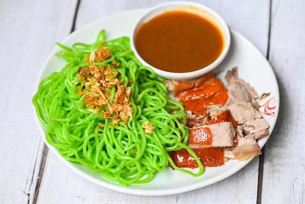 Jade noodle Aziatische Thailand eten geroosterde eend met jade noodle op witte plaat en eend saus groene noedels Chinees eten