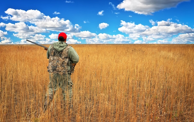 Jager beweegt met jachtgeweer op zoek naar prooi in het veld. Jager met een pistool. Op haas jagen