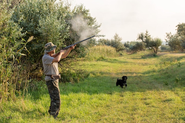 Jager man in camouflage met een pistool tijdens de jacht op zoek naar wilde vogels of wild Herfst jachtseizoen