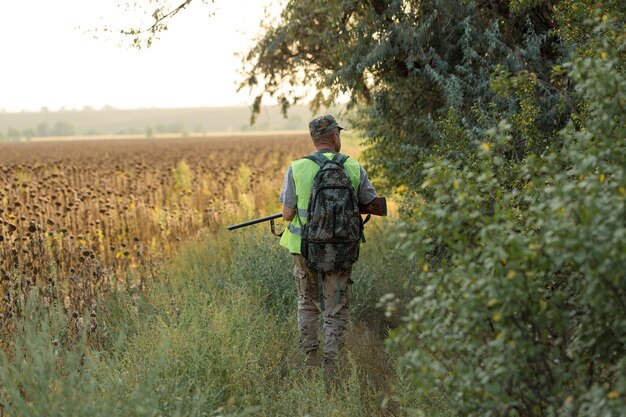 Jager man in camouflage met een pistool tijdens de jacht op zoek naar wilde vogels of wild.