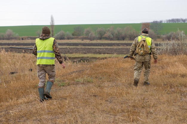 Jager man in camouflage met een pistool tijdens de jacht op zoek naar wilde vogels of wild.