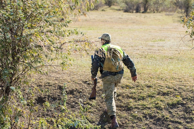 Jagerman in camouflage met een pistool tijdens de jacht op zoek naar wilde vogels of wild