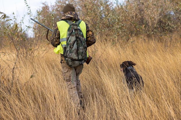 Jagerman in camouflage met een pistool tijdens de jacht op zoek naar wilde vogels of wild