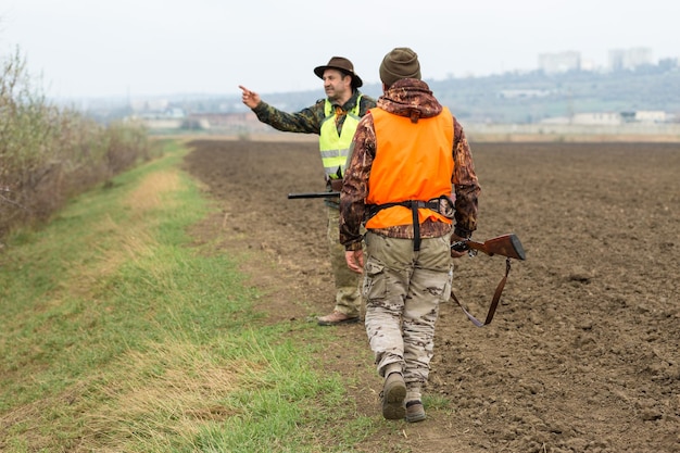 Jagerman in camouflage met een pistool tijdens de jacht op zoek naar wilde vogels of wild