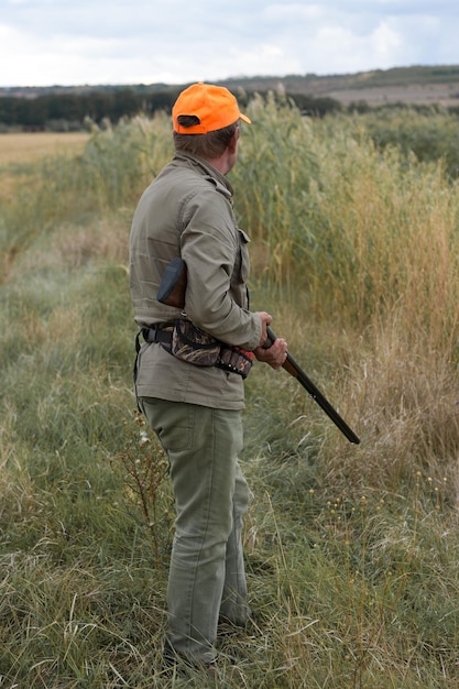 Jagerman in camouflage met een pistool tijdens de jacht op zoek naar wilde vogels of wild