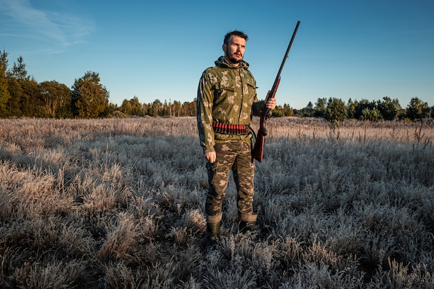 Jagersmens in camouflage met een kanon tijdens de jacht op zoek naar wilde vogels