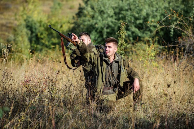 Jagervriend geniet van vrije tijd in het veld Jagers jachtopzieners op zoek naar dier of vogel Jagen met vrienden hobby vrije tijd Hobby voor echte mannen concept Jagers met geweren in de natuur