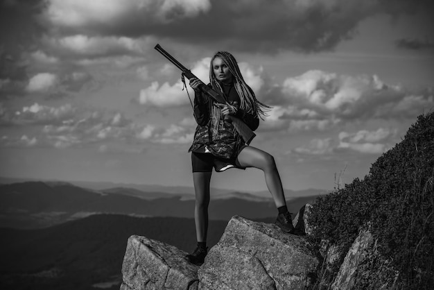 Jagervrouw die een pistool vasthoudt en in het bos loopt jagersopleiding gesloten en open jachtseizoen