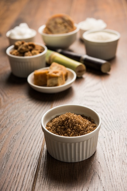 Jaggery, Sugar Variety and Sugarcane - by-products of Sugar Cane or Ganna placed over moody background. Selective focus