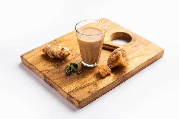 Photo jaggery tea or gur ki chai with ingredients like gud ginger or adrak green cardamom and cinnamon