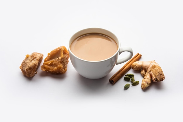 Photo jaggery tea or gur ki chai with ingredients like gud ginger or adrak green cardamom and cinnamon