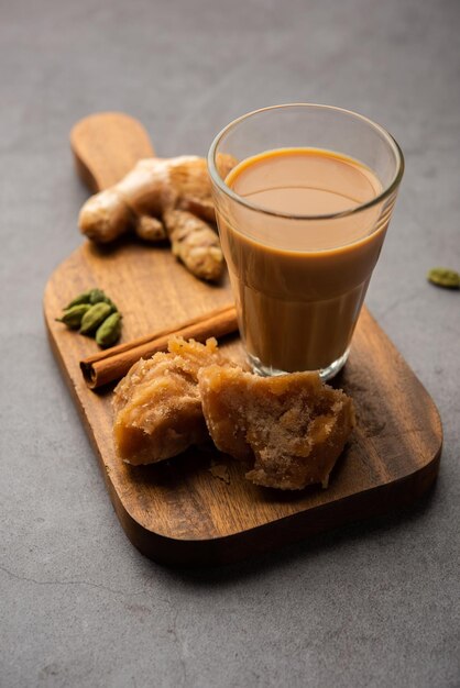 Photo jaggery tea or gur ki chai with ingredients like gud ginger or adrak green cardamom and cinnamon