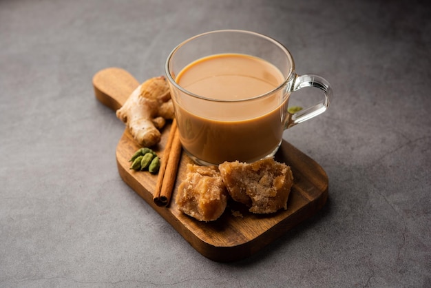 Tè jaggery o gur ki chai con ingredienti come zenzero gud o cardamomo verde adrak e cannella