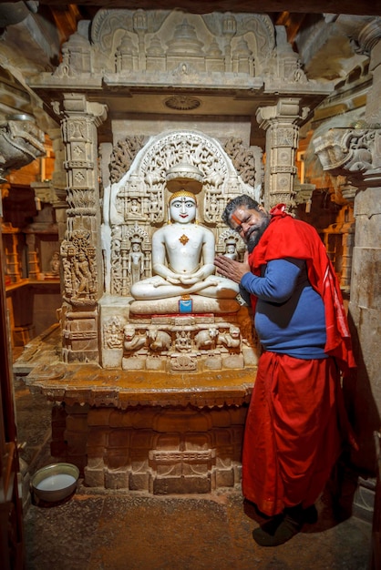 Джайсалмер, Раджастан, Индия, 5 января 2020 г .: служитель джайнского храма молится у алтаря.