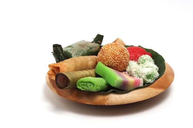 Photo jajan pasar traditional indonesian market snacks on the wooden plate with banana leaves isolated