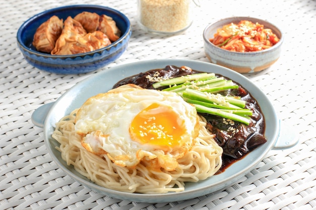 Jajang Myeon or JJajangmyeon Korean Noodle with Black Bean Sauce, Served with Cucumber and Sesame Seed