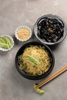 Jajangmyeon o jjajangmyeon noddle coreano con salsa di fagioli neri, servito con cetriolo e semi di sesamo
