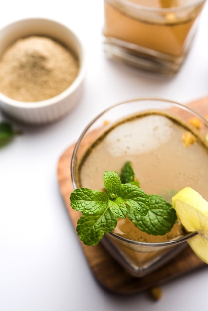 Jal-Jeera OR Jaljira is an Indian beverage prepared using mixing cumin powder in water and served cold with Boondi, Mint and Lemon slice. Served over moody background. Selective focus