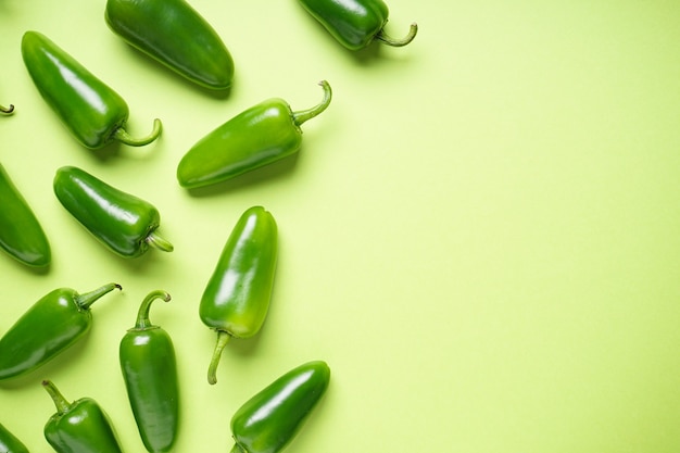 Photo jalapeno chili peppers, on a green background, place for text. top view.