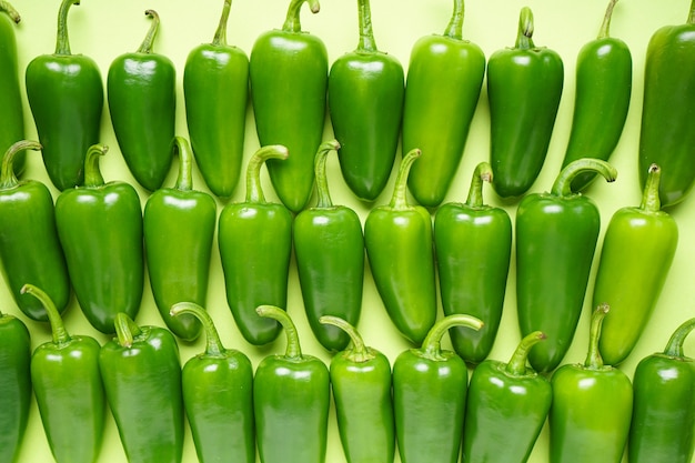 Jalapeno green peppers, on a green background. Flat lay.