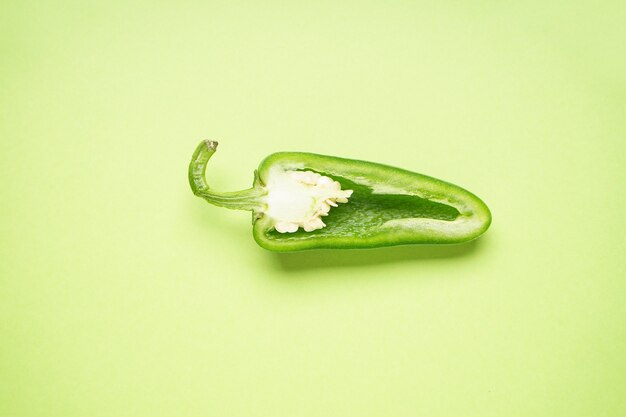 Photo jalapeno pepper, cut, on a light green background. flat lay.