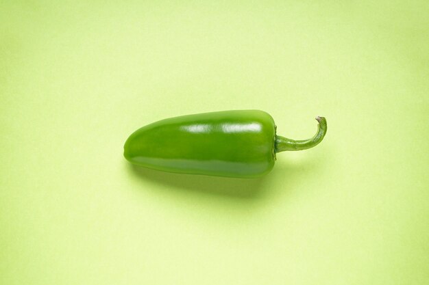Jalapeno pepper, cut, on a light green background.