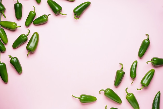 Jalapeno peppers, on a pink background, place for text. Flat lay.