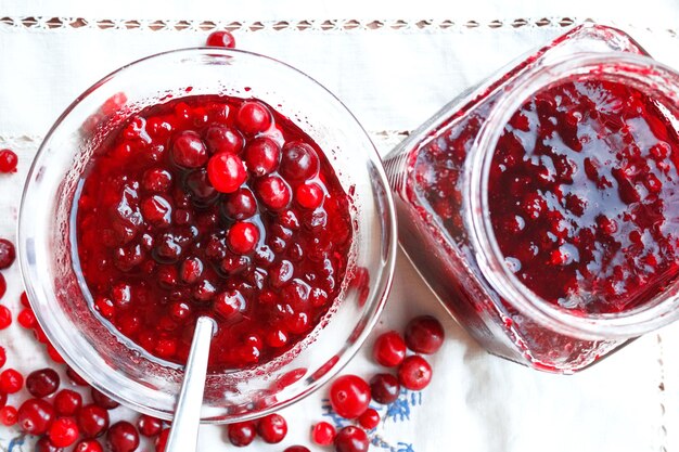 Jam bank with berries top view on a white tablecloth