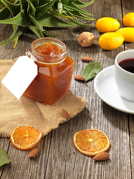 Jam jar with fruit on wooden base