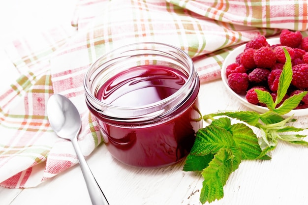 Jam of raspberry in jar on light board top