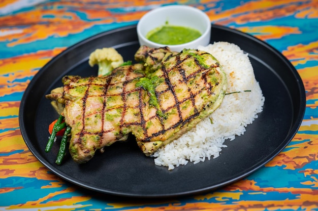 Photo jamaican jerk chicken with lemon butter rice and sauce