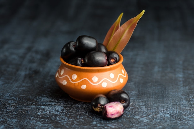 Jambolan-pruim of jambul of Jamun-fruit, Java-pruim met blad op getextureerde steen