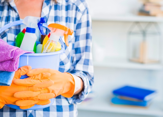 Janitor holding cleaning equipments in bucket