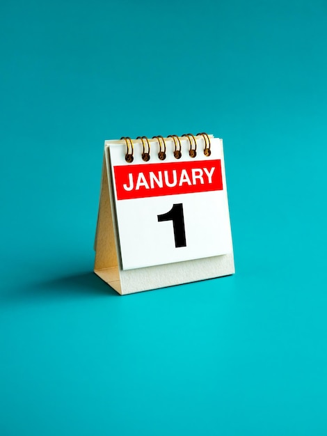 January 1 page with big number on desk folding calendar standing isolated on light blue background First day of the month and year vertical Happy New Year holidays in January minimal style