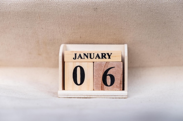 Photo january 6th image of jan 6 wooden color calendar on white canvas background empty space for text