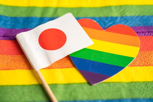 Photo japan flag on rainbow background symbol of lgbt gay pride month social movement rainbow flag is a symbol of lesbian gay bisexual transgender human rights tolerance and peace