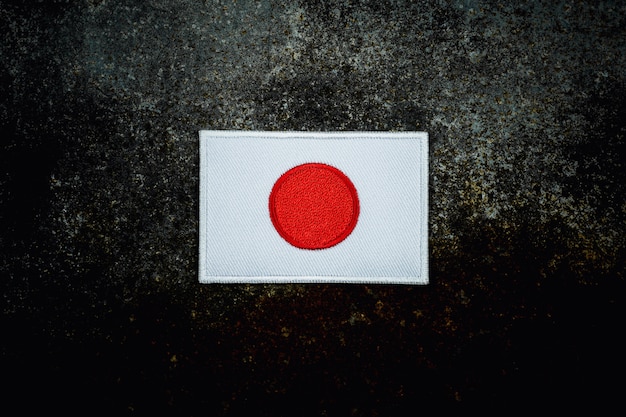 Japan flag on rusty abandoned metal floor in the dark.