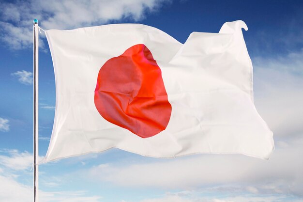 Photo japan flag waving under blue sky