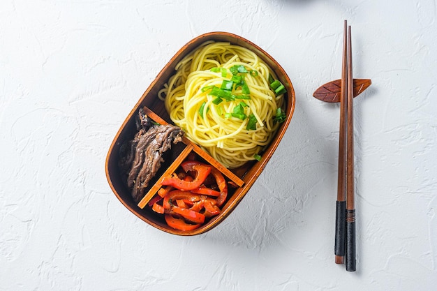 Cibo giapponese, carne alla griglia e pranzo bento confezionato con bacchette vista dall'alto spazio per il testo.