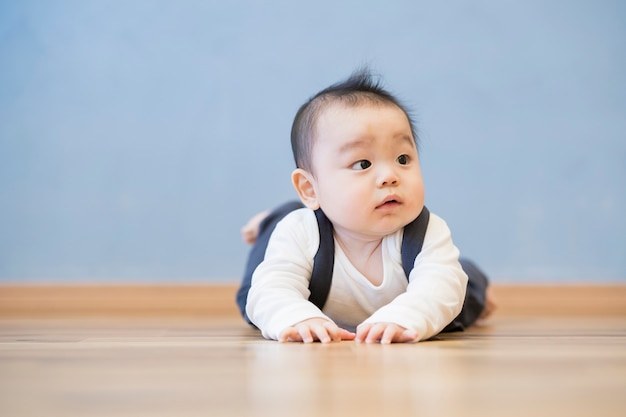 방에 나무 바닥에 기어가는 일본 아기