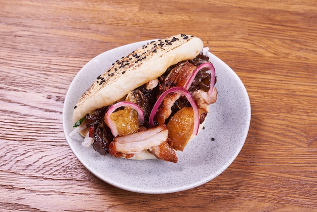 Japanese bao with chicken, sauce, onion and sesame seeds. Selective focus