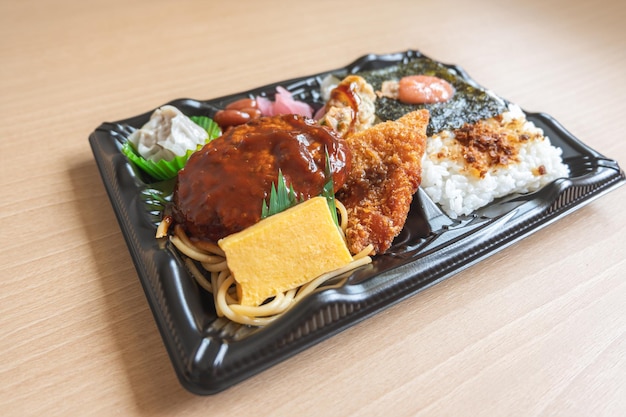 Japanese bento set lunch box of hamburger steak seaweed on rice fried fish and Japanese rolled omelet