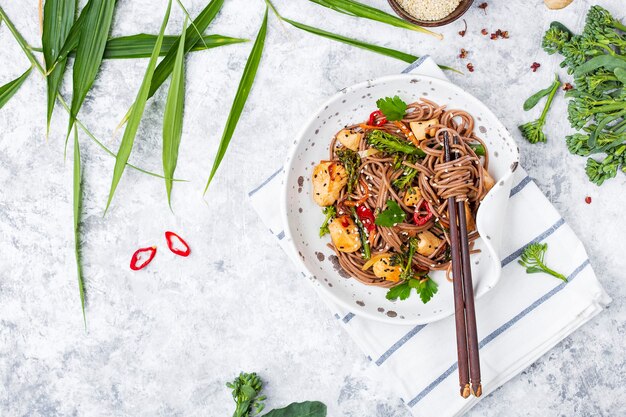 明るい背景に鶏肉と野菜を添えた日本のそば麺焼きそば